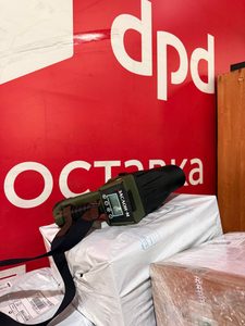 Портативный обнаружитель следов взрывчатых веществ на посылках у стены с логотипом DPD